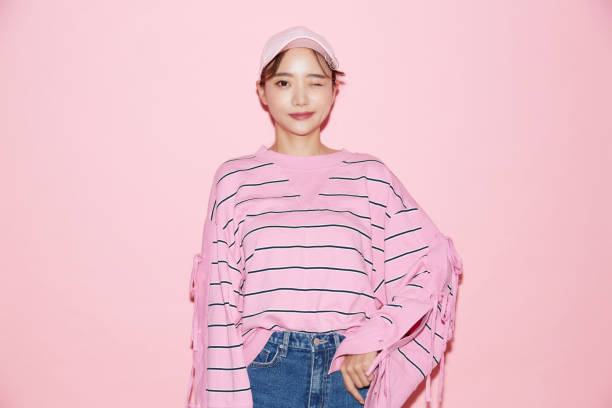 retrato de una joven asiática casual con gorra sobre fondo rosa - maquillaje kawaii fotografías e imágenes de stock