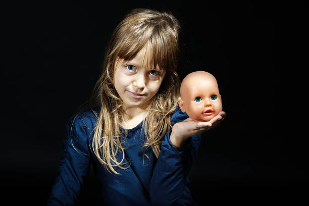 portrait of child blonde with broken doll portrait of little child blonde girl with broken doll in studio with black background broken doll 1 stock pictures, royalty-free photos & images