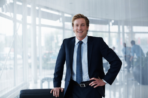 Portrait of confident businessman standing with hand on hip in office
