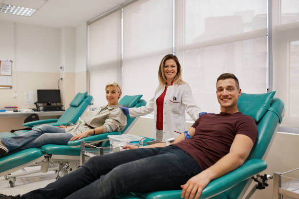 Portrait Of Doctor With Blood Donors In Blood Bank stock photo