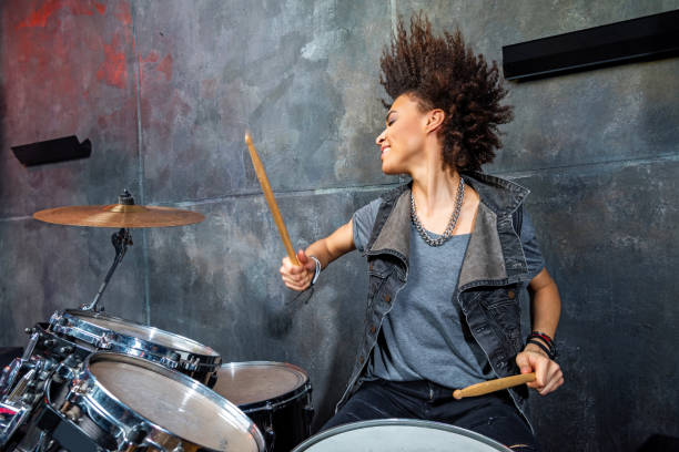 portret van emotionele vrouw die trommels in studio, drummer rotsconcept speelt - drums stockfoto's en -beelden