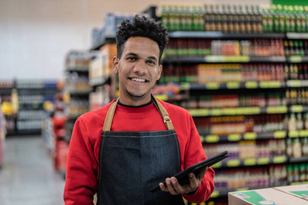 Portrait of employee checking inventory in a digital tablet at a supermarket Portraits pardo brazilian stock pictures, royalty-free photos & images