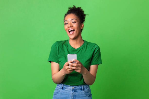 portrait of excited black woman using her mobile phone - people cellphone imagens e fotografias de stock