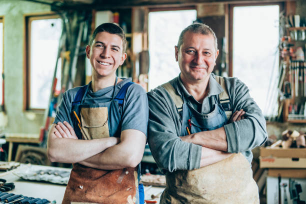 Portrait of Father and Son Carpenters Father and son carpenters in their wood workshop craftsperson photos stock pictures, royalty-free photos & images