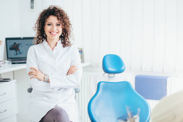 Portrait of female dentist. She standing at her office and she has beautiful smile. stock photo