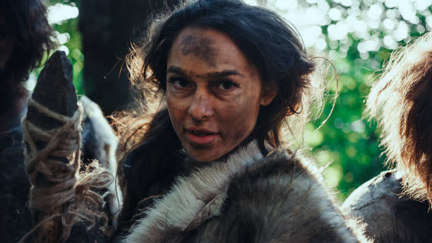 porträt von female primeval cavemen leader und warrior threat enemy mit stein-spitzenspeer, schrei, verteidigung ihrer höhle und territorium in den prähistorischen zeiten. neandertaler / homo sapiens stamm - neandertaler stock-fotos und bilder