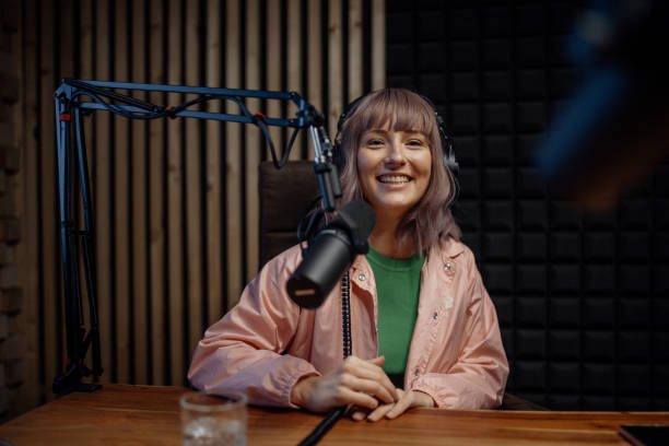 Portrait of female radio host speaking in microphone while moderating a live show stock photo