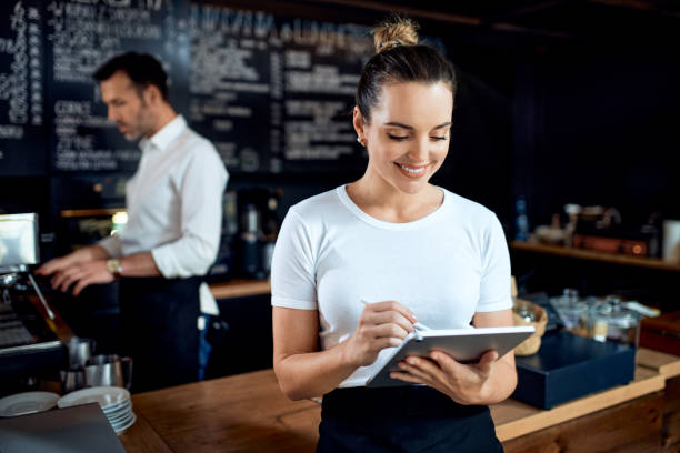 Portrait of female small business owner using digital tablet at restaurant cafe stock photo