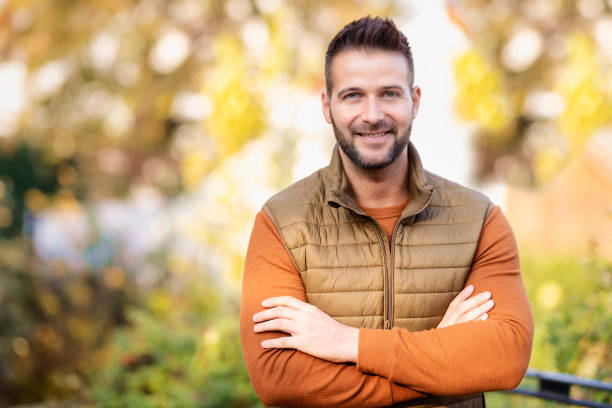 Portrait of handsome man standing outdoor in the autumn weather stock photo