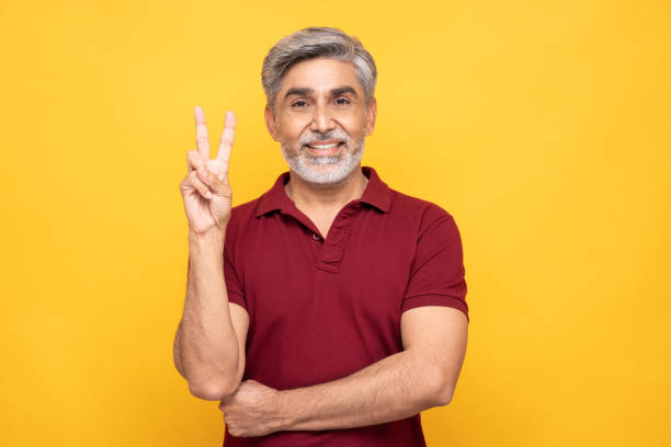 portrait of handsome mature man isolated over yellow background:- stock photo stock photo