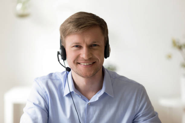 porträtt av stilig leende man som arbetar i hörlurar på kontoret - virtual reality headset bildbanksfoton och bilder