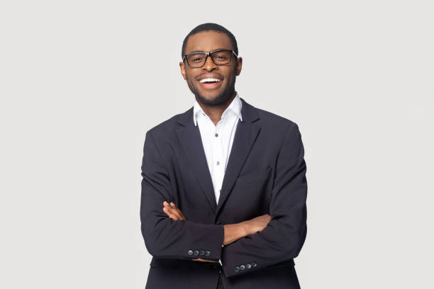 Portrait of happy african american young businessman in formal suit. Happy african american young businessman in formal suit wearing eyeglasses portrait. Smiling millennial confident black guy posing for photo, looking at camera, isolated on grey studio background. business suit stock pictures, royalty-free photos & images