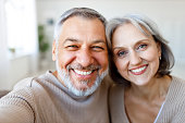 istock Portrait of happy beautiful senior caucasian couple smiling at camera while making selfie 1342960215
