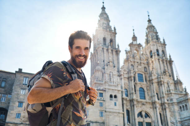 Portrait Of Happy Man On Pilgrimage At Santiago De Compostela Portrait Of Happy Male Pilgrim Looking At Camera And Smiling In Santiago de Compostela, Spanish Town At The End Of The Camino De Santiago. pilgrims monument stock pictures, royalty-free photos & images