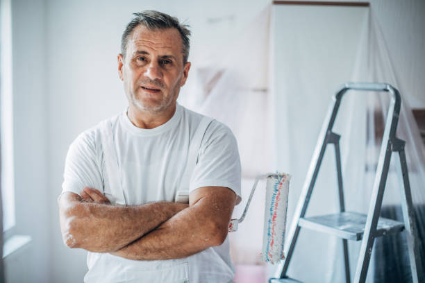 Portrait of happy painter Painter standing with crossed arms in the living room eastern europe stock pictures, royalty-free photos & images