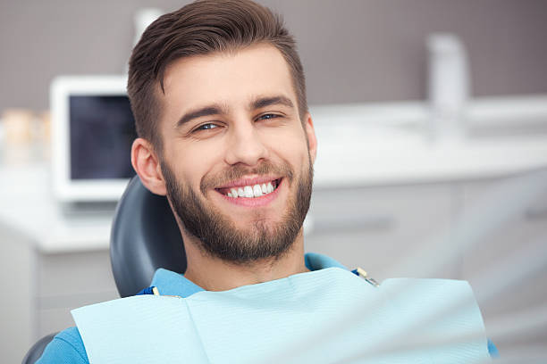 Portrait of happy patient in dental chair. stock photo