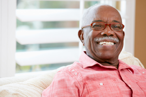 Portrait Of Happy Senior Man At Home Looking At Camera Smiling