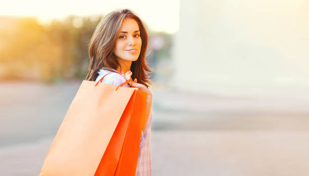Portrait of happy smiling young brunette woman with shopping bags in the city stock photo