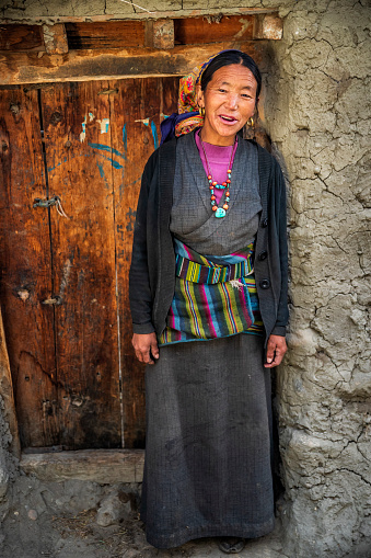 Portrait of happy Tibetan woman in small village in Upper Mustang. Mustang region is the former Kingdom of Lo and now part of Nepal,  in the north-central part of that country, bordering the People's Republic of China on the Tibetan plateau between the Nepalese provinces of Dolpo and Manang.