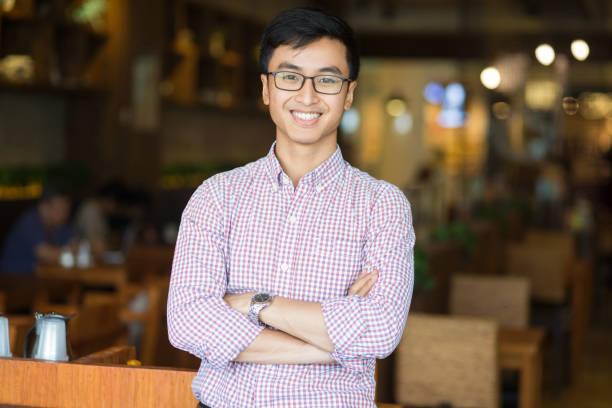 Portrait of happy young Asian businessman in cafe stock photo