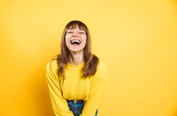 Portrait of happy young woman smiling at camera isolated on bright yellow background Portrait of happy young woman smiling at camera isolated on bright yellow background generation z photos stock pictures, royalty-free photos & images