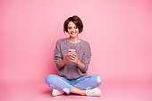 Portrait of her she nice attractive lovely charming pretty cute cheerful cheery, brown-haired girl sitting using cell 5g app isolated over pink pastel color background
