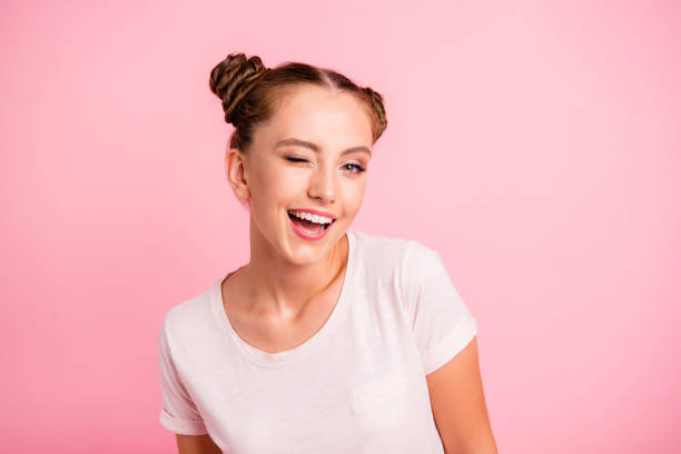 Portrait of hipster beautiful, attractive, pretty lady in white, casual t-shirt wear isolated on vivid pink background lovely blink eyed and open mouth Portrait of hipster beautiful, attractive, pretty lady in white, casual t-shirt wear isolated on vivid pink background lovely blink eyed and open mouth flirting stock pictures, royalty-free photos & images