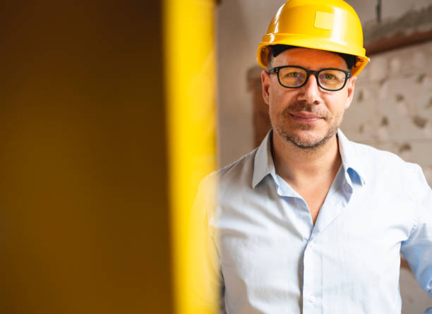 Portrait of male architect with yellow safety helmet and blue shirt stock photo