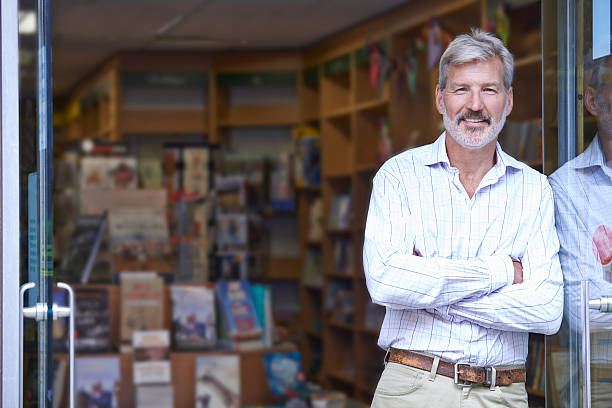 Portrait Of Male Bookshop Owner Outside Store Portrait Of Male Bookshop Owner Outside Store bookstore stock pictures, royalty-free photos & images