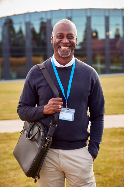 Portrait Of Male University Or College Tutor Outdoors With Modern Campus Building In Background stock photo