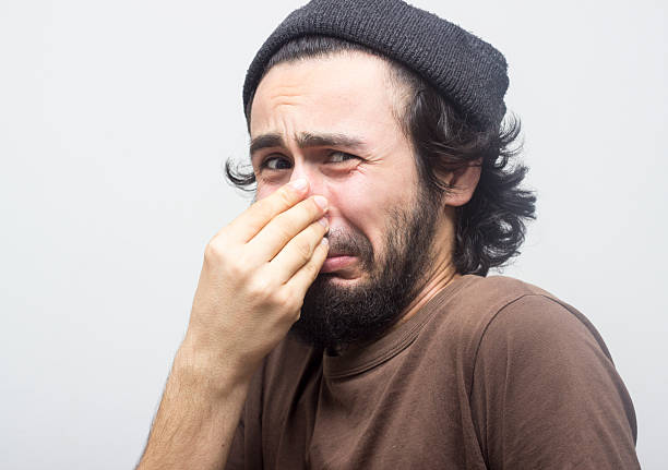 portrait-of-man-holding-his-nose-in-terr