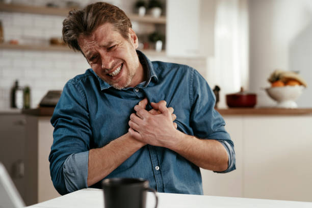 Portrait of man placing hands on the chest suffering from pain in the heart. stock photo