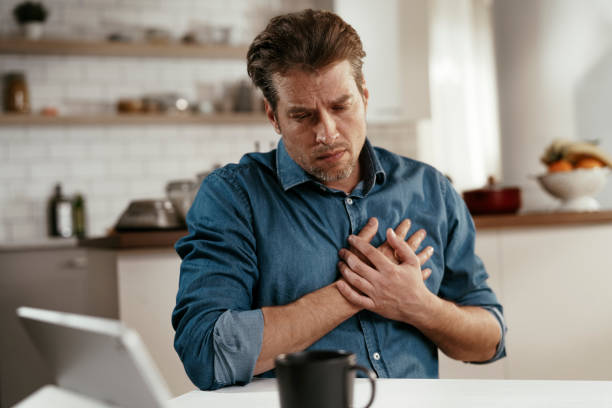 Portrait of man placing hands on the chest suffering from pain in the heart. stock photo