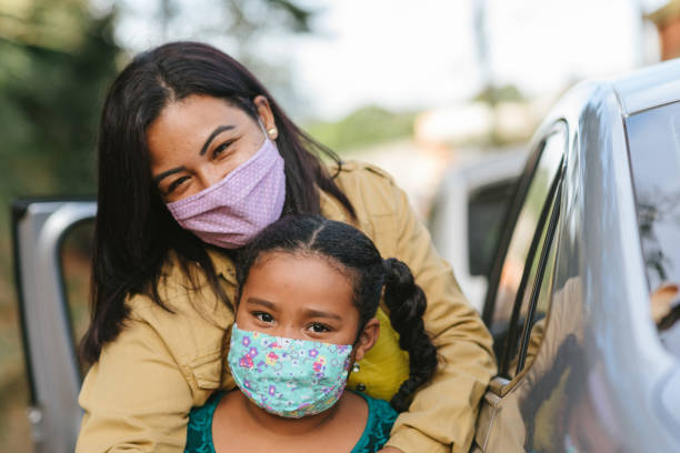 portrait of mother and daughter wearing protective mask on the street - máscara de proteção imagens e fotografias de stock