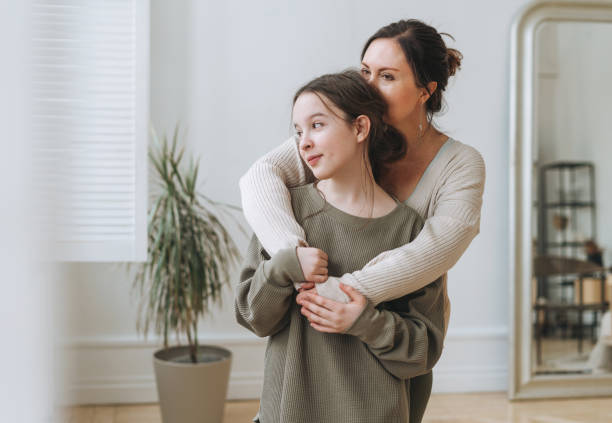 Portrait of mother middle age woman and daughter teenager together in thelight interior stock photo