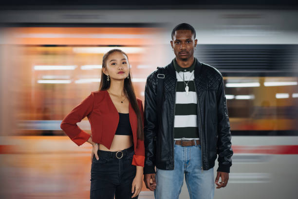 Portrait of multi-ethnic friends at subway Teenage friends, of different ethnicity, are standing in front of train on the move and looking at camera. medium shot stock pictures, royalty-free photos & images