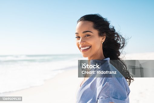 istock Portrait of natural beauty woman at beach 1369509530