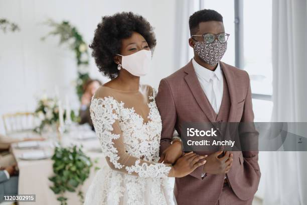 Portrait of newlyweds wearing face protective masks at their wedding due Covid-19