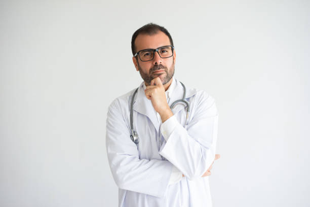 Portrait of pensive mid adult medic wearing lab coat and glasses stock photo