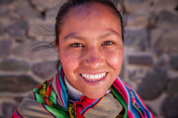 Portrait of Peruvian young woman near Ollantaytambo The Sacred Valley of the Incas or Urubamba Valley is a valley in the Andes  of Peru, close to the Inca capital of Cusco and below the ancient sacred city of Machu Picchu. The valley is generally understood to include everything between Pisac  and Ollantaytambo, parallel to the Urubamba River, or Vilcanota River or Wilcamayu, as this Sacred river is called when passing through the valley. It is fed by numerous rivers which descend through adjoining valleys and gorges, and contains numerous archaeological remains and villages. The valley was appreciated by the Incas due to its special geographical and climatic qualities. It was one of the empire's main points for the extraction of  natural wealth, and the best place for maize production in Peru. peru woman stock pictures, royalty-free photos & images
