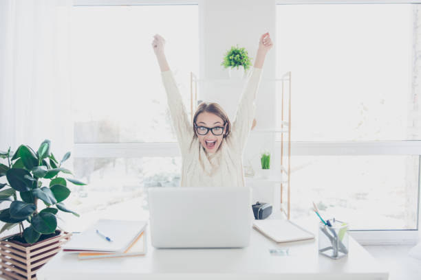 Portrait of positive glad woman holding hands up yelling looking at screen of laptop celebrating achievement successfully completed job project presentation internet xfi complete stock pictures, royalty-free photos & images