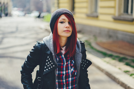Portrait of young woman with red hair and leather jacket