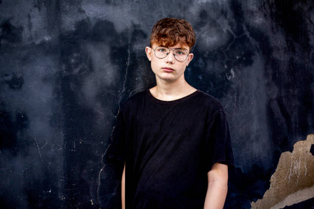 Portrait of red-haired teen boy with freckles and eyeglasses stock photo