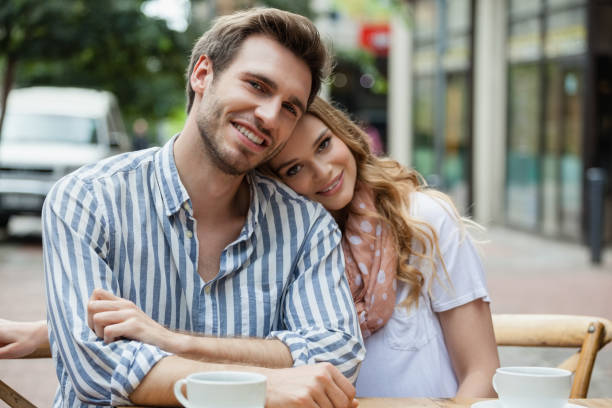 Portrait of romantic couple sitting at sidewalk cafe Portrait of romantic couple sitting at sidewalk cafe in city cougar woman stock pictures, royalty-free photos & images