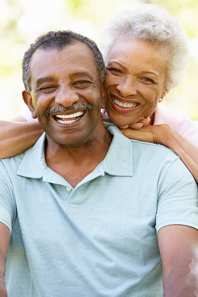 Portrait Of Romantic Senior African American Couple In Park Portrait Of Romantic Senior African American Couple Sitting In Park Laughing Together old black couple in love stock pictures, royalty-free photos & images