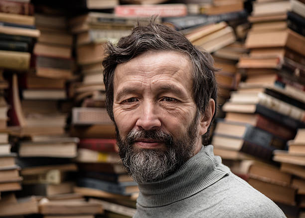 Portrait of senior man with beard on book market stock photo