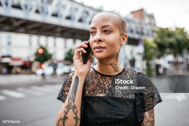 Portrait of serious modern mixed race woman in the city, using smart phone for talking