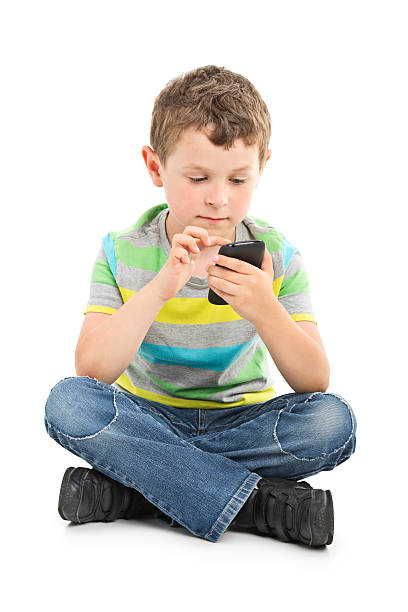 portrait of small boy playing with mobile phone stock photo