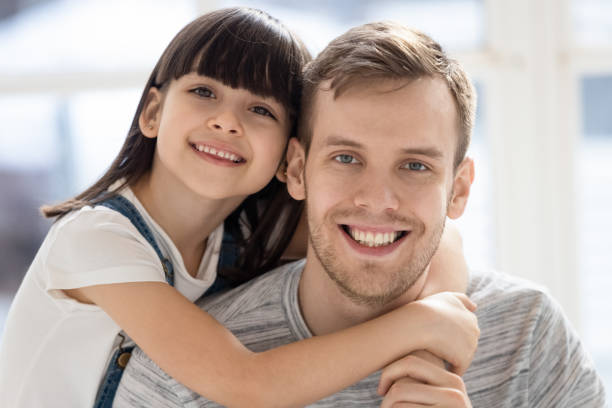 portret van glimlachende vader en weinig dochter die koestert - piggyback hurt dad stockfoto's en -beelden