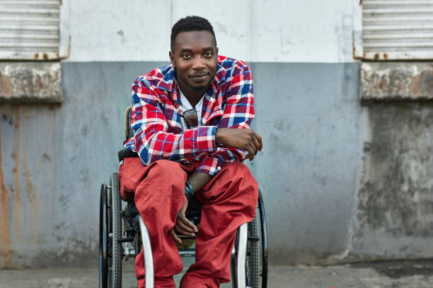 portrait of smiling disabled man on wheelchair - wheelchair street imagens e fotografias de stock